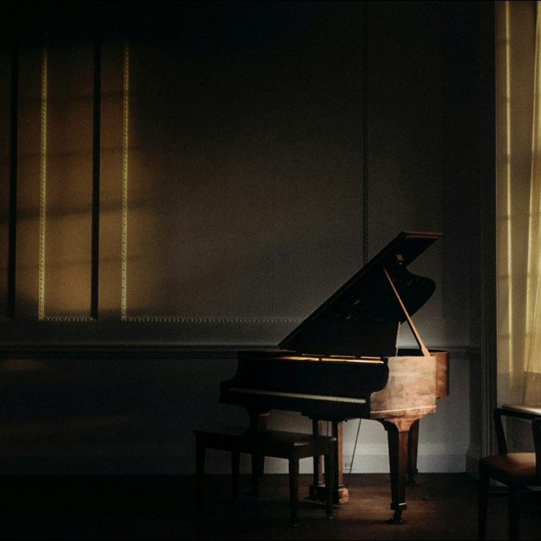 Window light over a grand piano